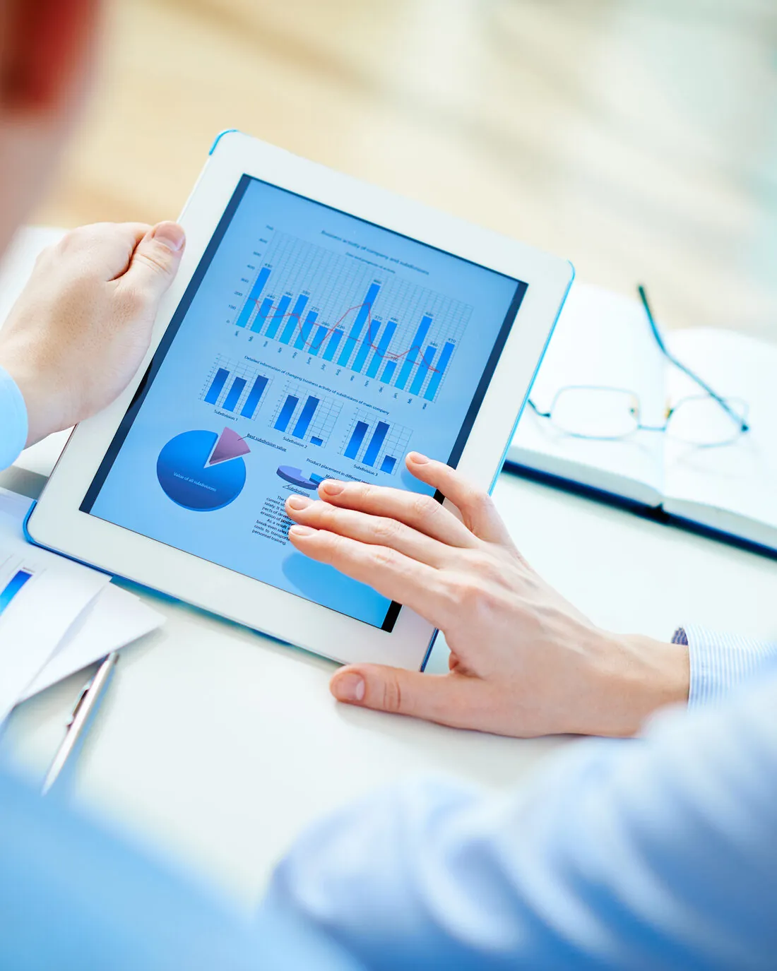 A partner and client reviewing operating charts together on a tablet